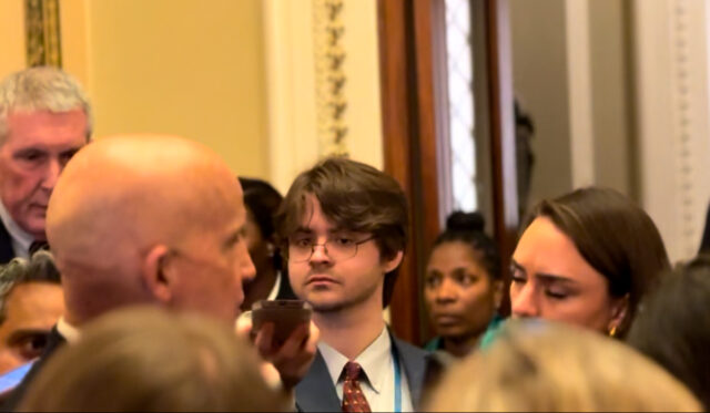 NonDoc reporter Kevin Eagleson participates in a media scrum outside of the House of Representatives.